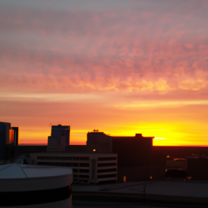 A skyline of a city with a sunset in the background.